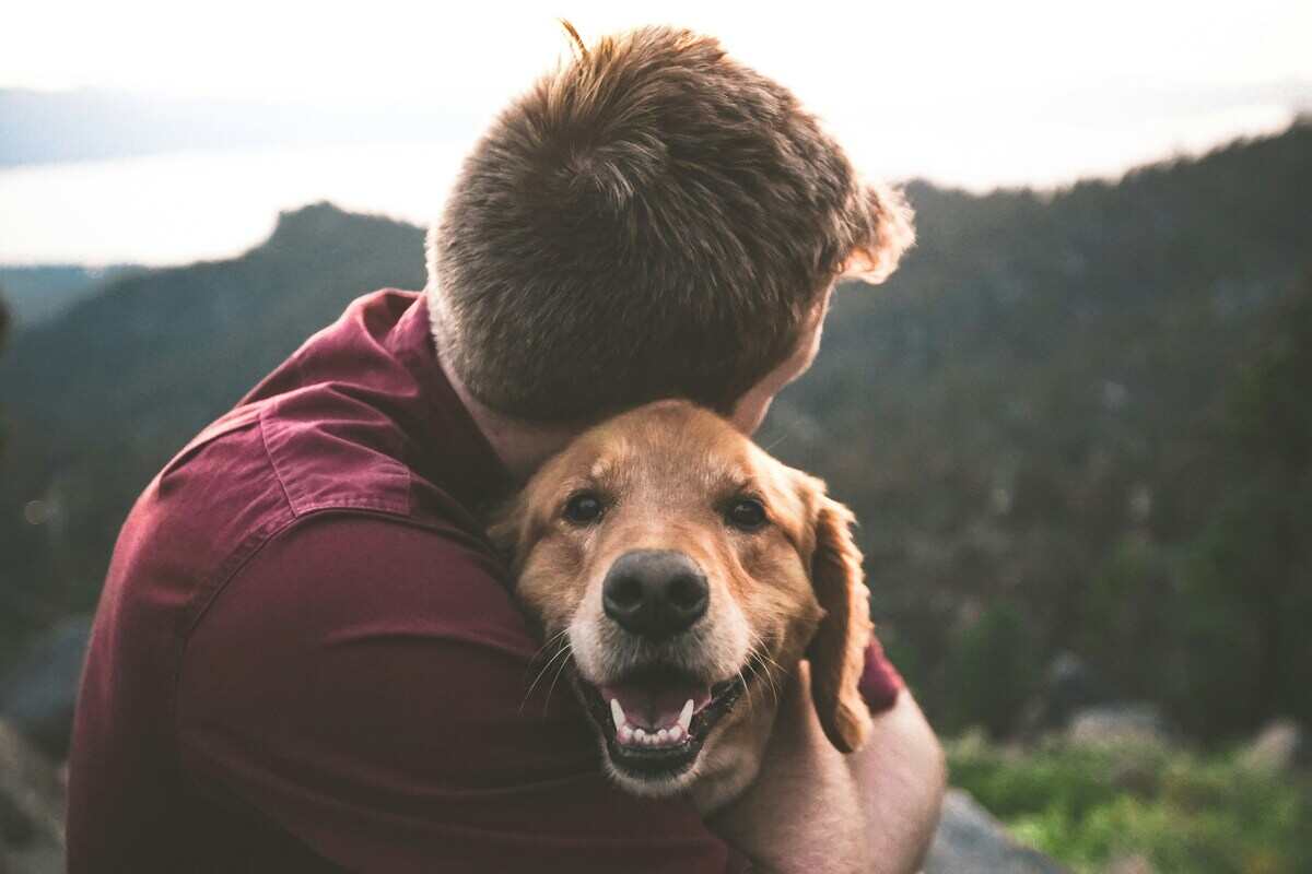 uomo abbraccia cane
