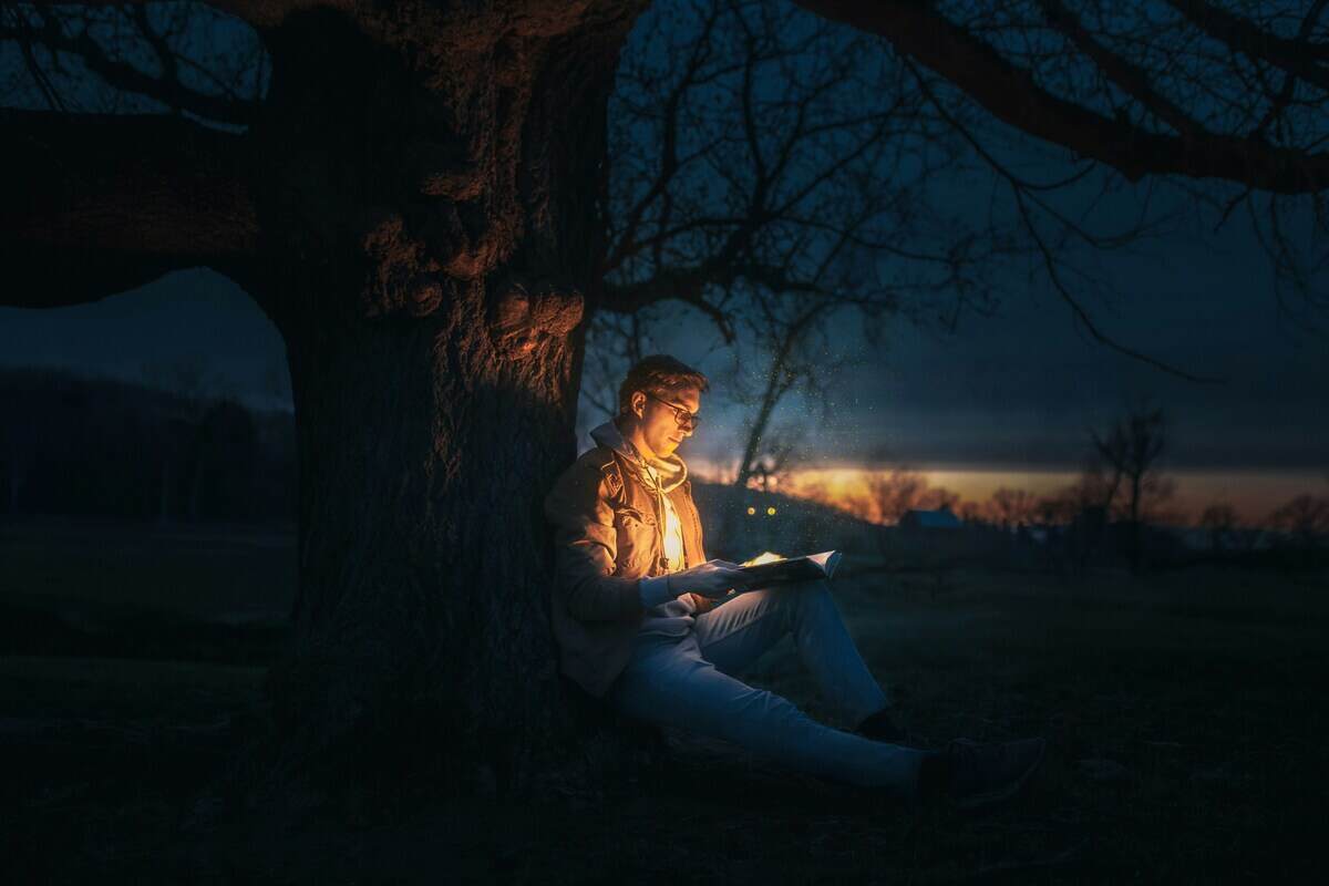 ragazzo legge libro al tramonto