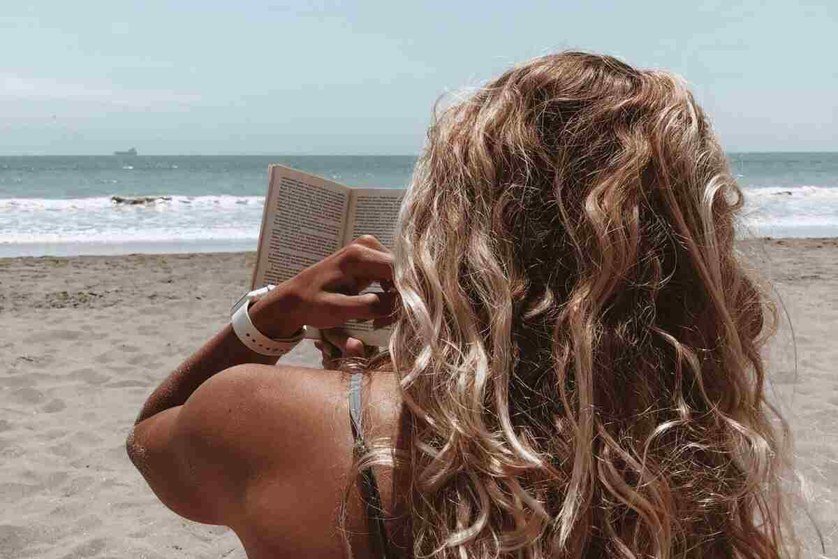 ragazza legge libro in spiaggia